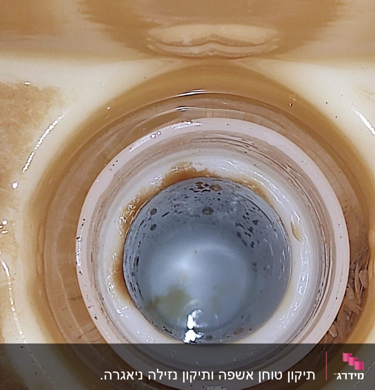 ניקוז כיור עם סימני חלודה ולכלוך